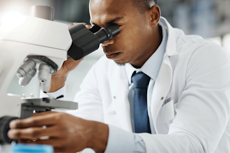 Dermatopathologist looking into microscope