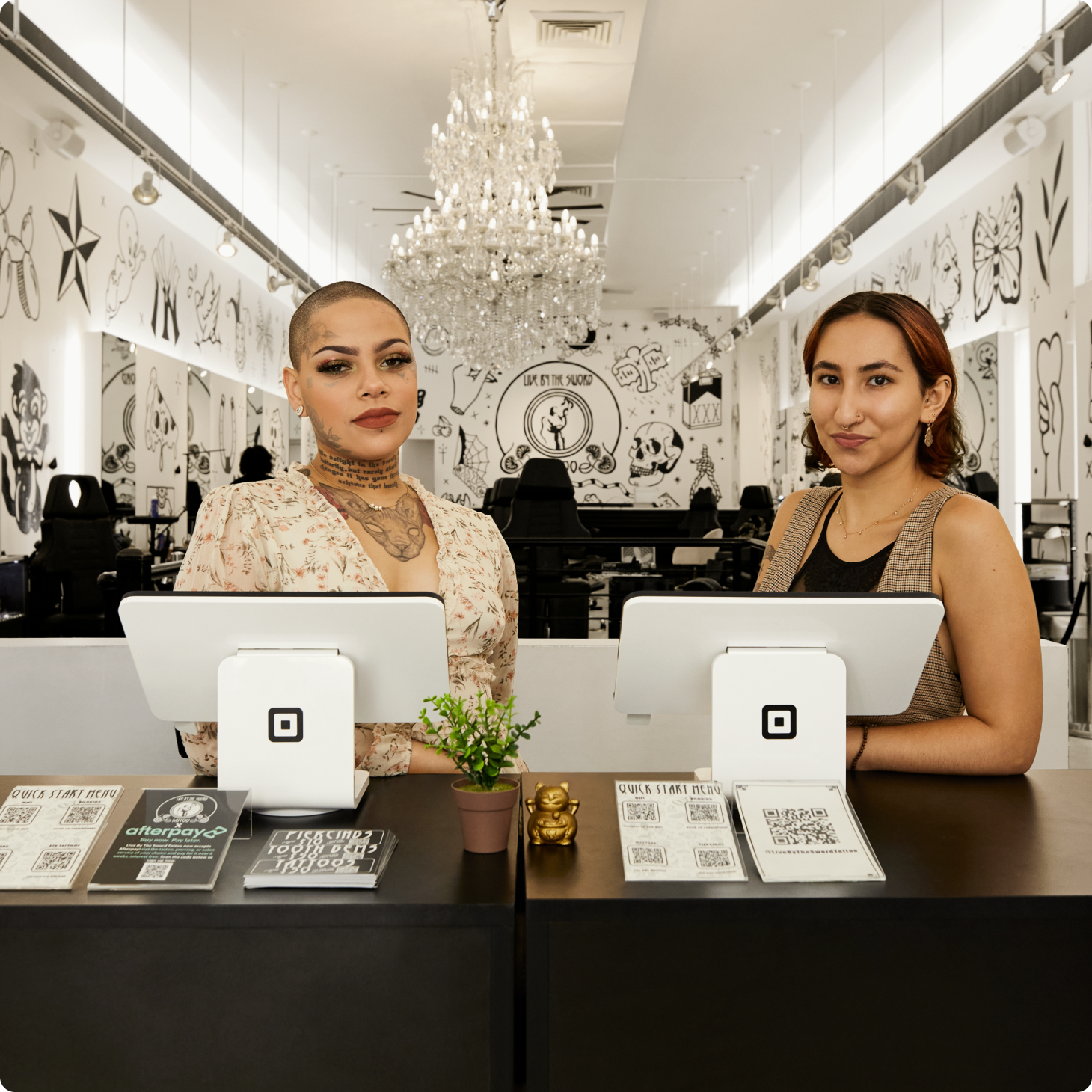Employees of a tattoo studio with two square stands.