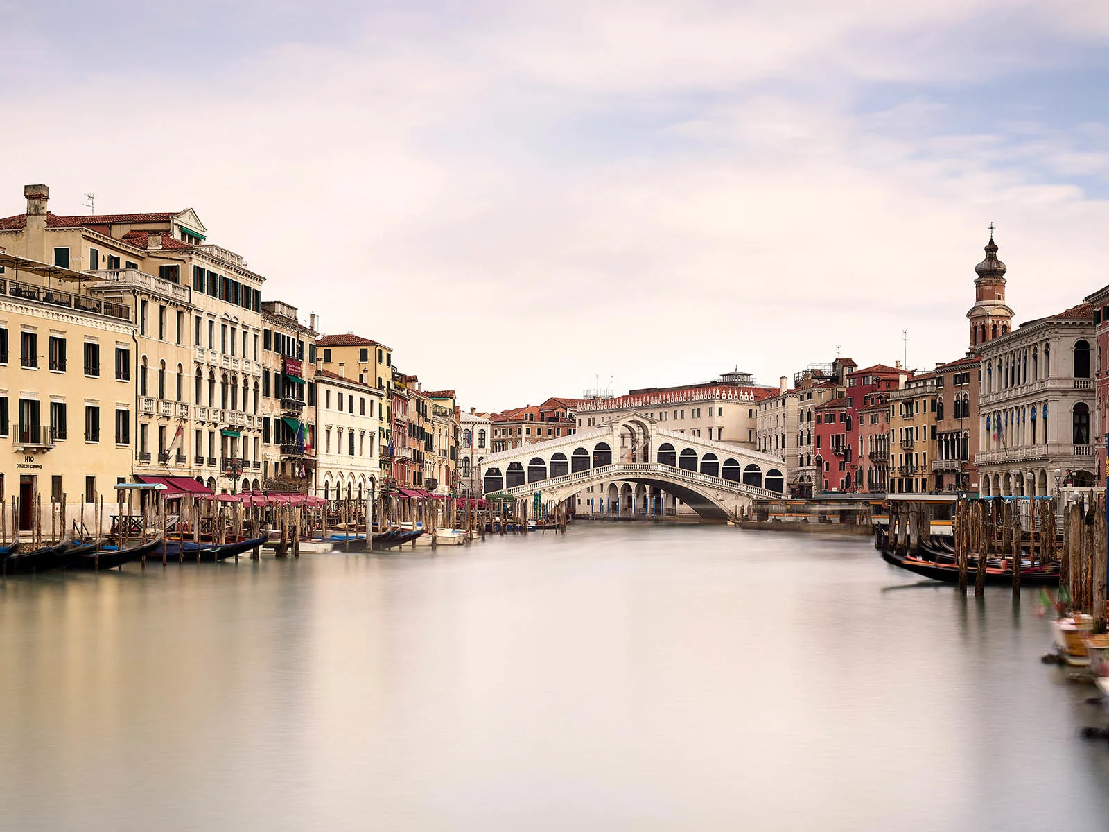 Vue sur le Grand Canal de Venise avec le Ponte di Rialto, flanqué de bâtiments historiques. Vue sur le Grand Canal de Venise avec le Ponte di Rialto, flanqué de bâtiments historiques.