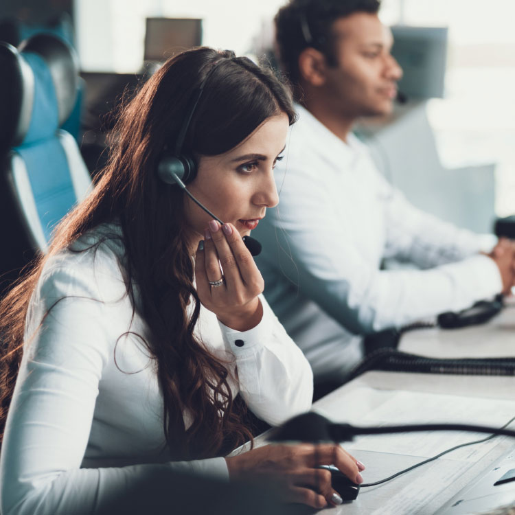 A woman in a headset takes a call while sitting in an emergency-response call center.