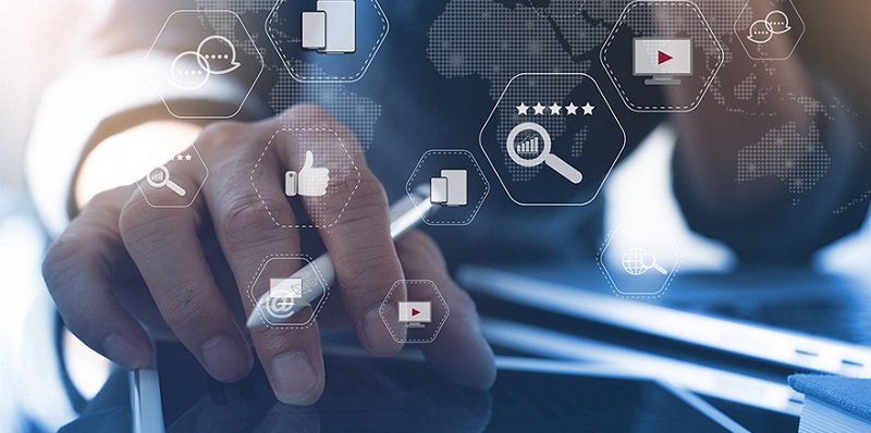 Hand with a pen on a tablet next to a laptop, overlaid with security icons and a digital map