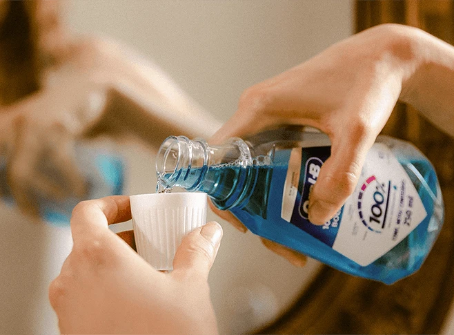 Woman using the Oral-B mouthwash