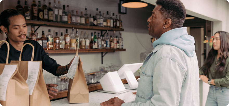 Customer picking up take-out order from counter with Station Duo in the background.