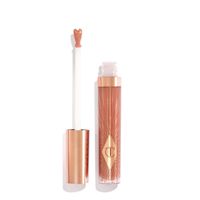 Brillant à lèvres Collagen Lip Bath en Pillow Talk avec le capuchon retiré Un brillant à lèvres rose nude ouvert de taille normale avec un applicateur en forme de cœur et un capuchon rose doré posé à côté.