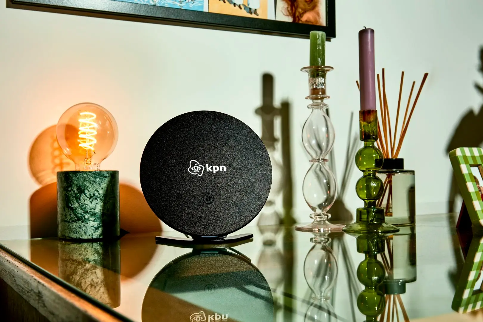 Zwart KPN SuperWifi punt op tafel naast een lamp