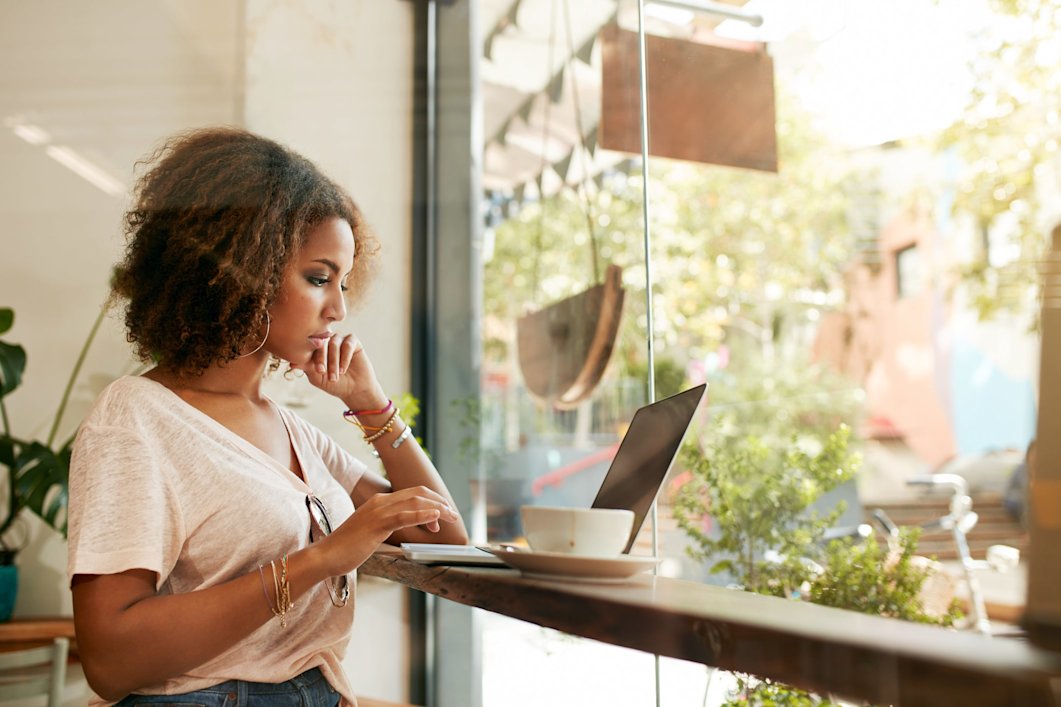 A young woman working remotely from a cafe