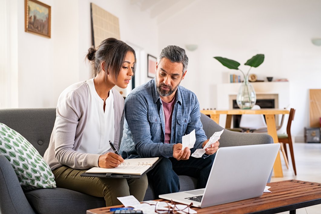A couple calculating their taxes and reviewing receipts at home.