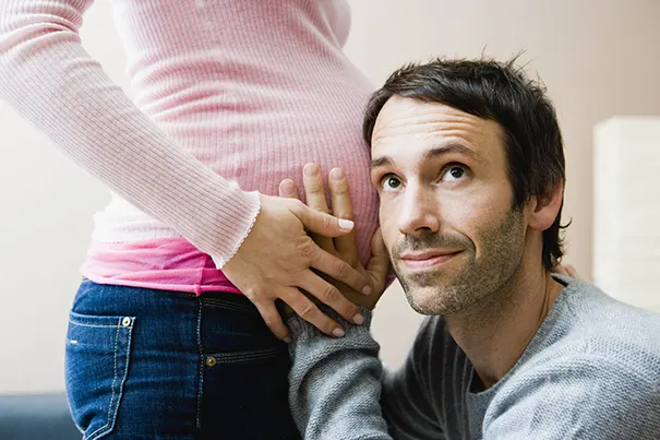 Papa horcht an Mamas Babybauch