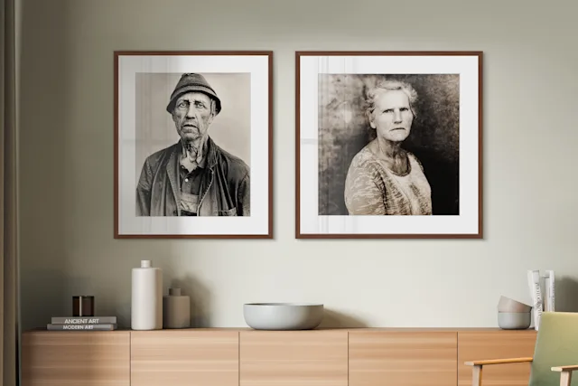 Zwei gerahmte Porträtfotos an der Wand, darunter Holzkommode mit Schalen, Büchern und Deko.
