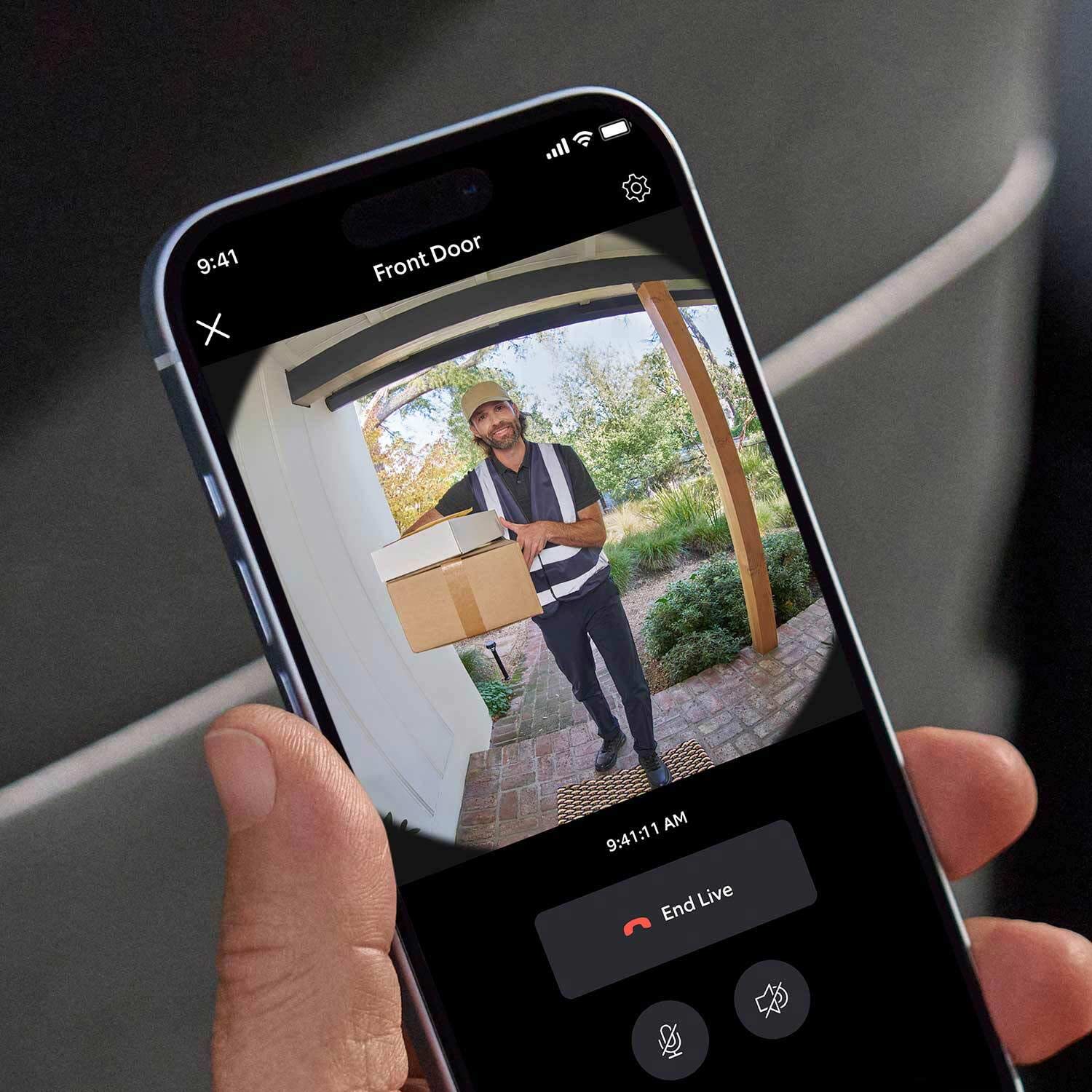 2-Pack Battery Doorbell - Hand holding a smartphone showing live Ring Battery Doorbell video of delivery person with packages at front door.