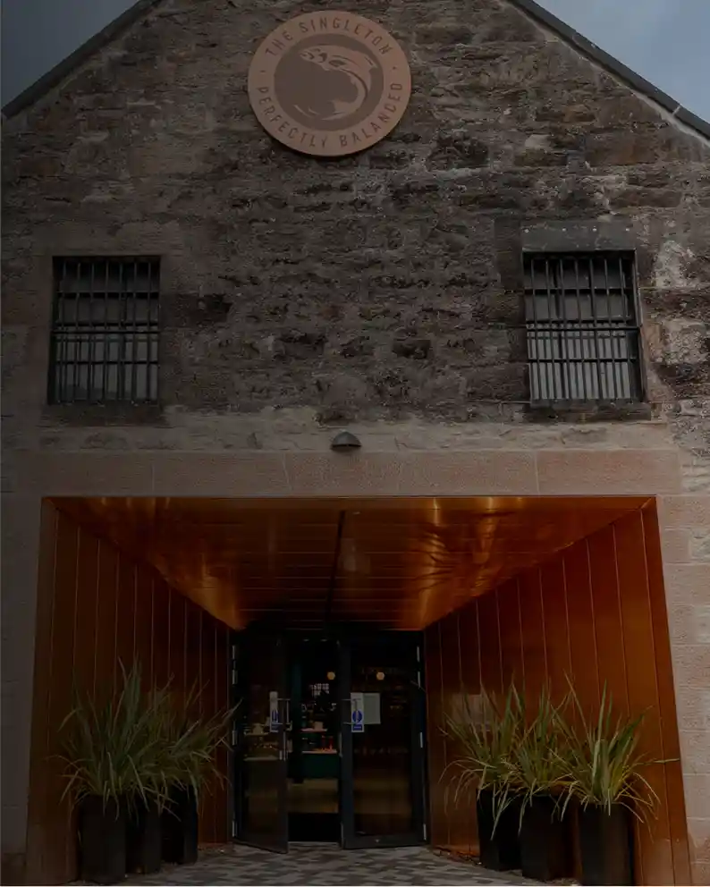 Entrance to Glen Ord Distillery with copper accents and The Singleton logo above the doorway.