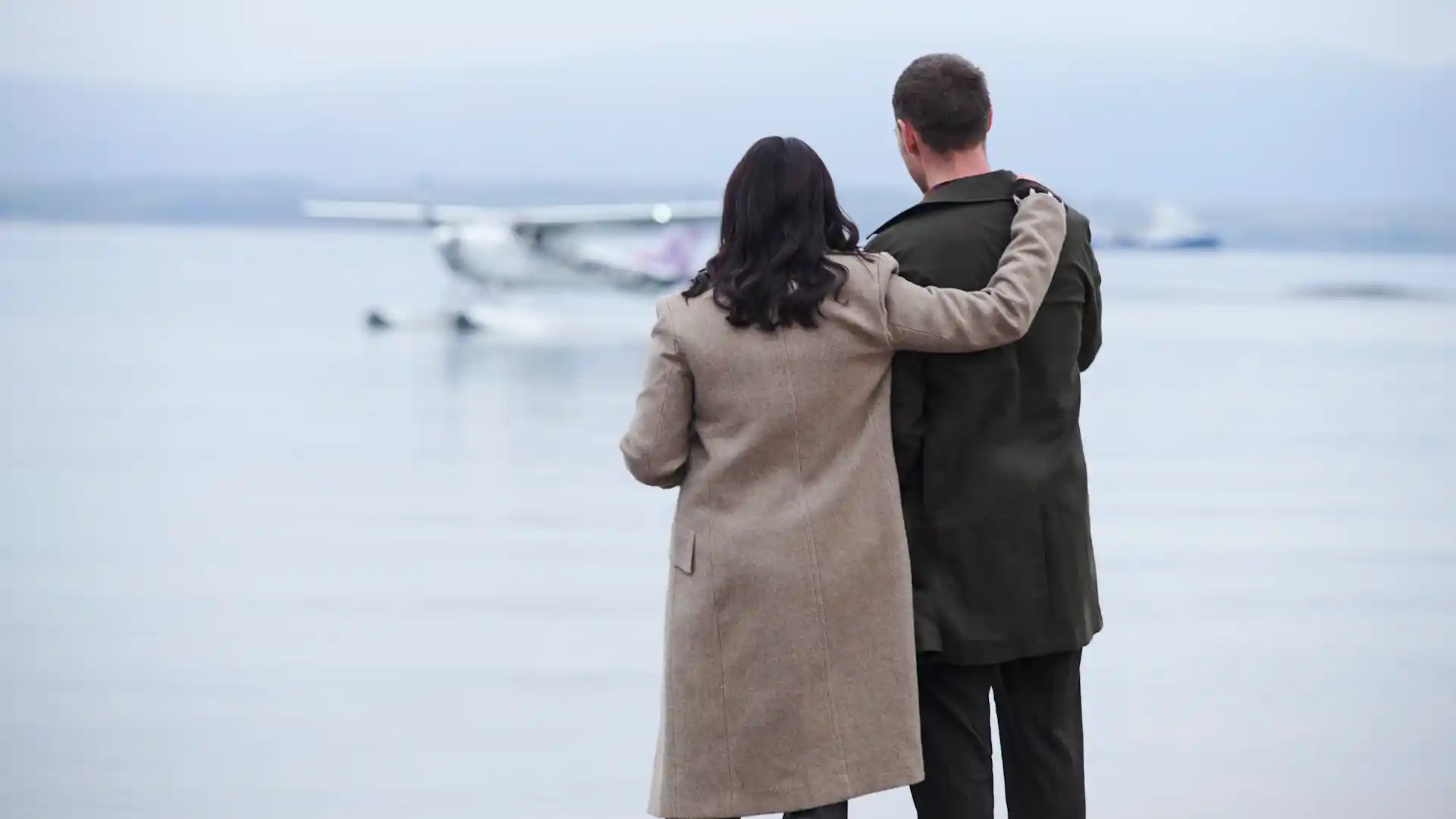 Een vrouw slaat haar arm om een man heen terwijl ze uitkijken over Oban Bay