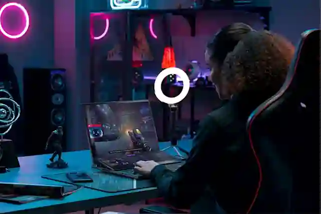 Gamer istuu pelituolissa ja pelaa peliä kannettavalla tietokoneella.