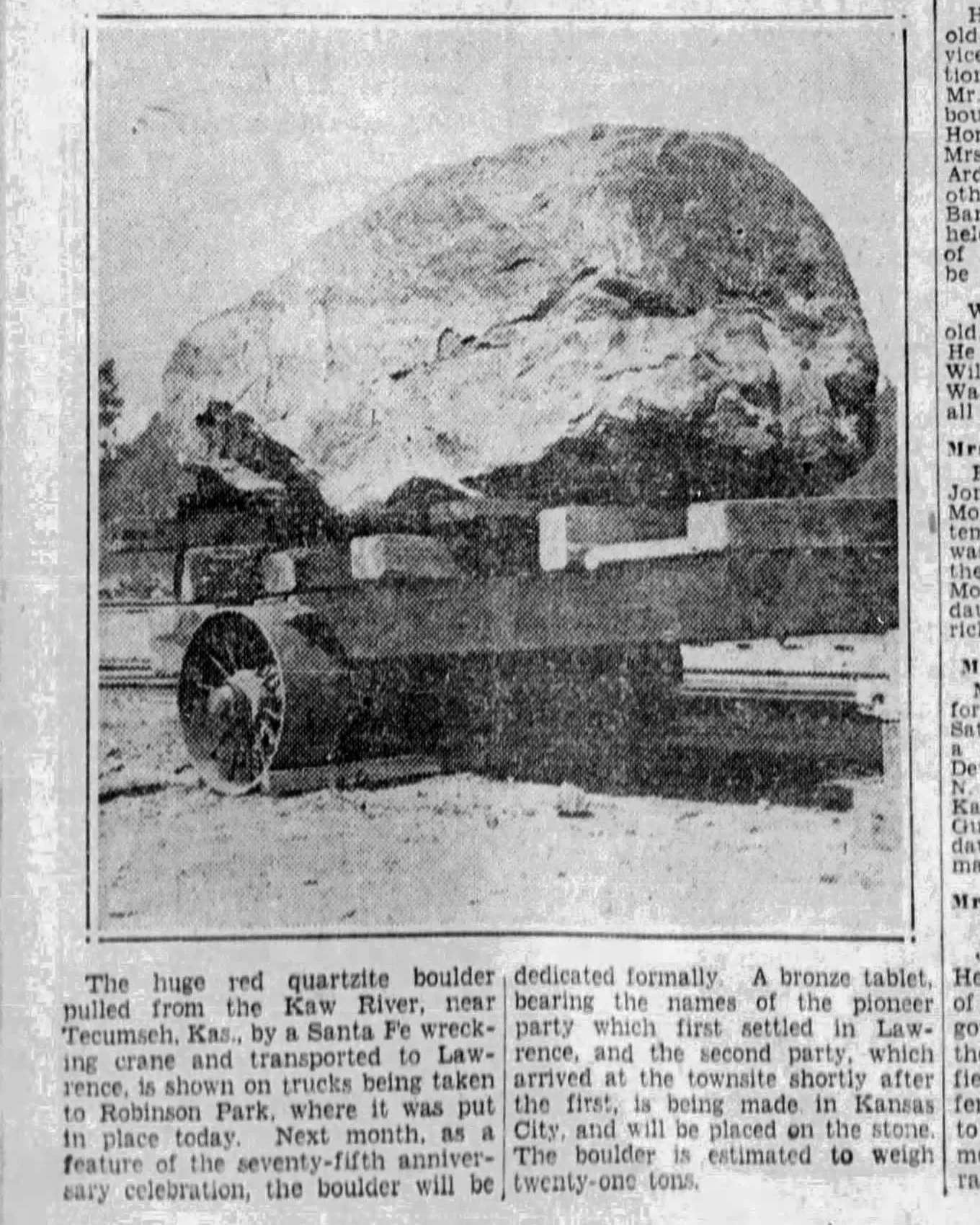 An old newspaper article displays a black and white photo of the Shunganunga boulder on a cart. The article reads "The huge red quartzite boulder pulled from the Kaw River, near Tecumseh, Kas., by a Santa Fe wrecking crane and transported to Lawrence, is shown on trucks being taken to Robinson Park, where it was put in place today. Next month, as a feature of the seventy-fifth anniversary celebration, the boulder will be dedicated formally. A bronze tablet, bearing the names of the pioneer party which first settled in Lawrence, and the second party, which arrived at the townsite shortly after the first, is being made in Kansas City, and will be placed on the stone. The boulder is estimated to weigh twenty-one tons."
