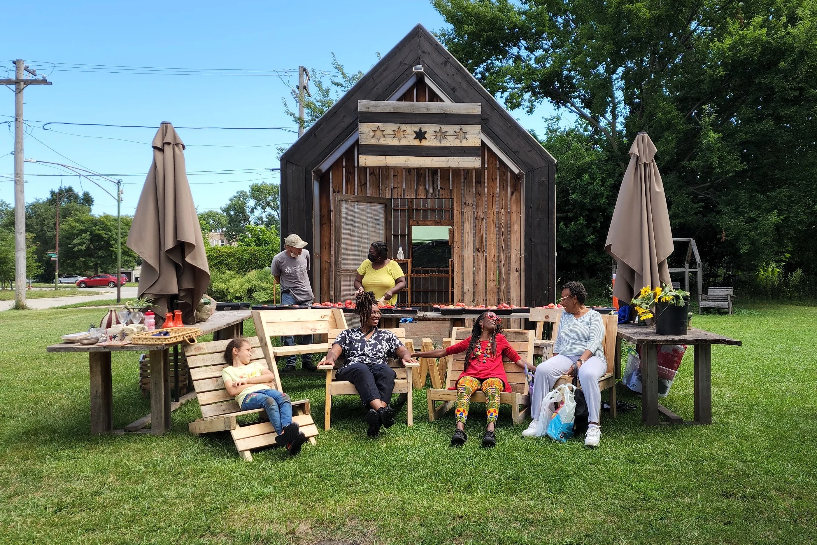 Six people are outside a park and meeting house