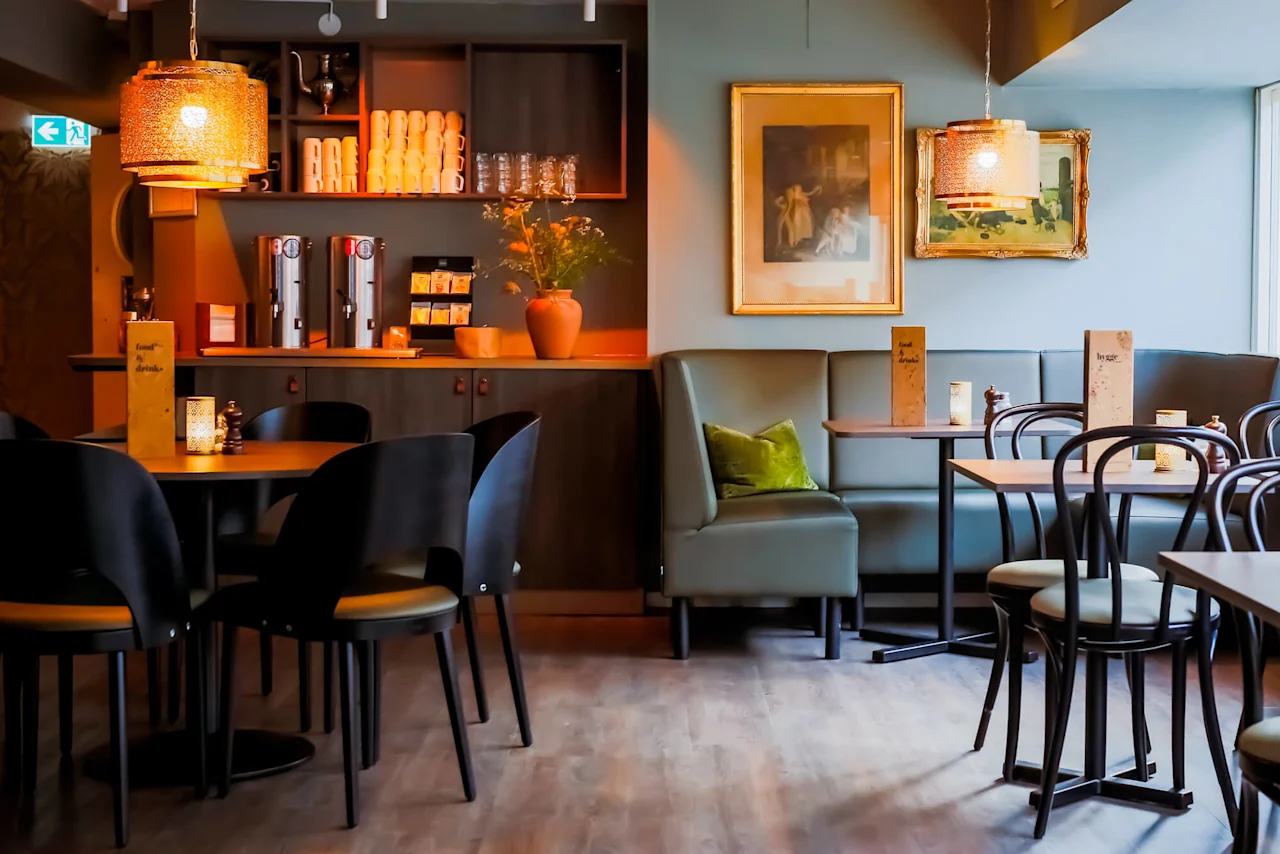 A cozy café interior with empty tables and chairs, ambient lighting, and various decorations.