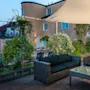 Outdoor furniture on a wooden deck with a large overhanging umbrella, residential buildings in the background.