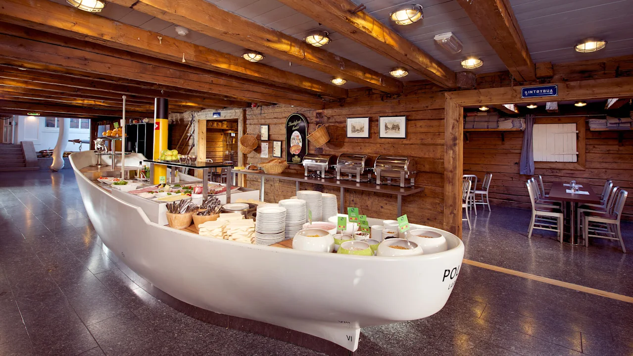 A half-boat buffet counter with food, set in a rustic wooden interior.