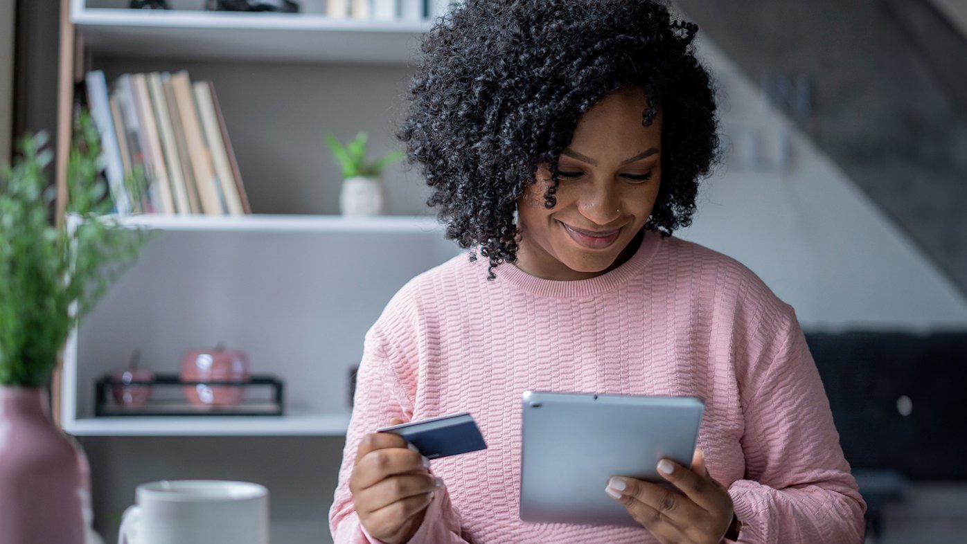 Woman paying her bill on tablet device with a credit card.