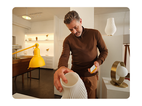 Homme achetant des céramiques fragiles dans une boutique de design.