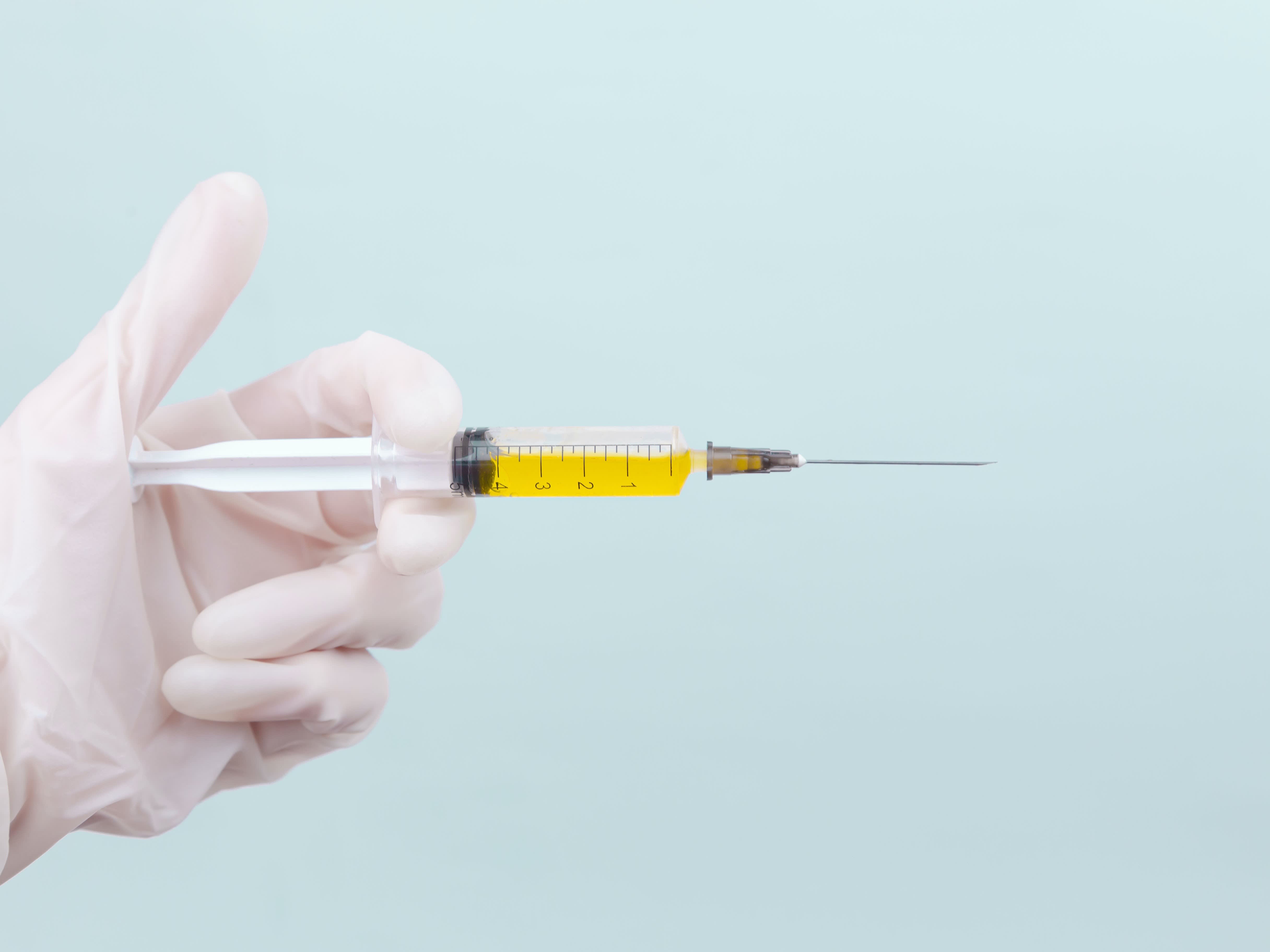 person holding yellow and white needle