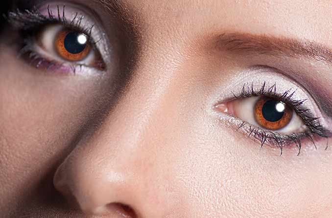 Mulher com cabelos pretos e olhos azuis com sebagai pupilas dilatadas