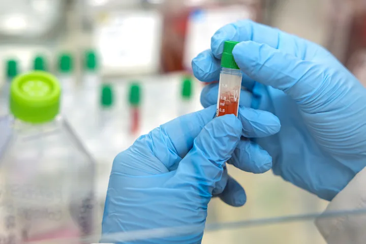 Close up on hands holding a vial in a research lab