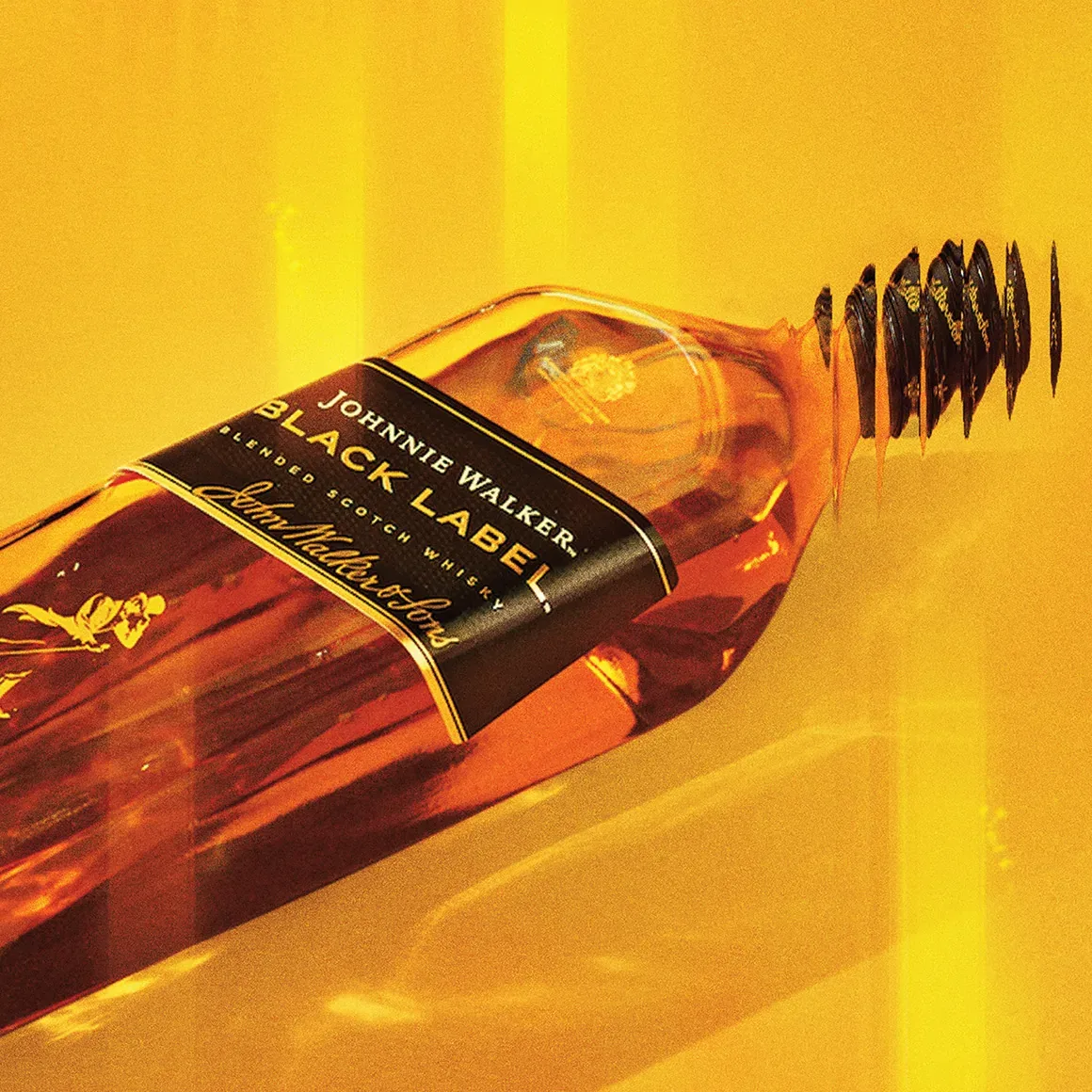 Botella de whisky Johnnie Walker Black Label tumbada horizontalmente sobre un fondo amarillo vibrante, con matices dorados que se reflejan en el cristal. La etiqueta es claramente visible, resaltando la marca premium.