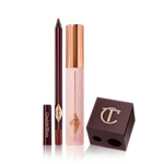 A berry-brown eyeliner pencil, black mascara with nude pink bottle and gold-coloured lid, and a dark crimson-coloured pencil and eyeliner sharpener.

