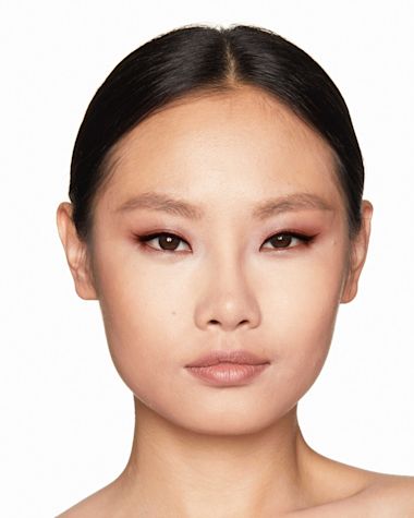 Fair-tone model with brown eyes with nude peach lipstick with a russet rose cream eyeshadow with a golden-peach sparkle.