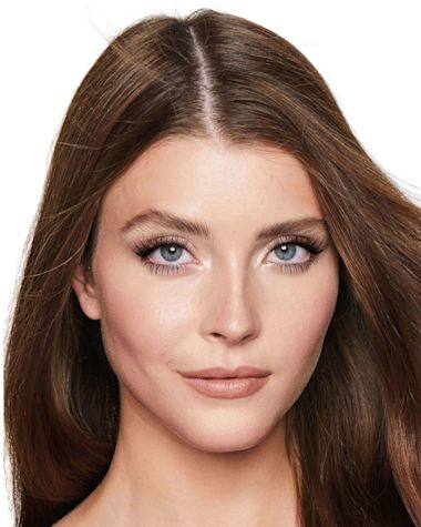 A fair-tone model with blue eyes wearing a jet black volumising mascara that makes her lashes long, defined, and curled. 
