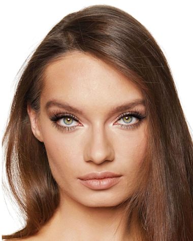 A medium-light-tone model with green eyes wearing a jet black volumising mascara that makes her lashes long, defined, and curled. 