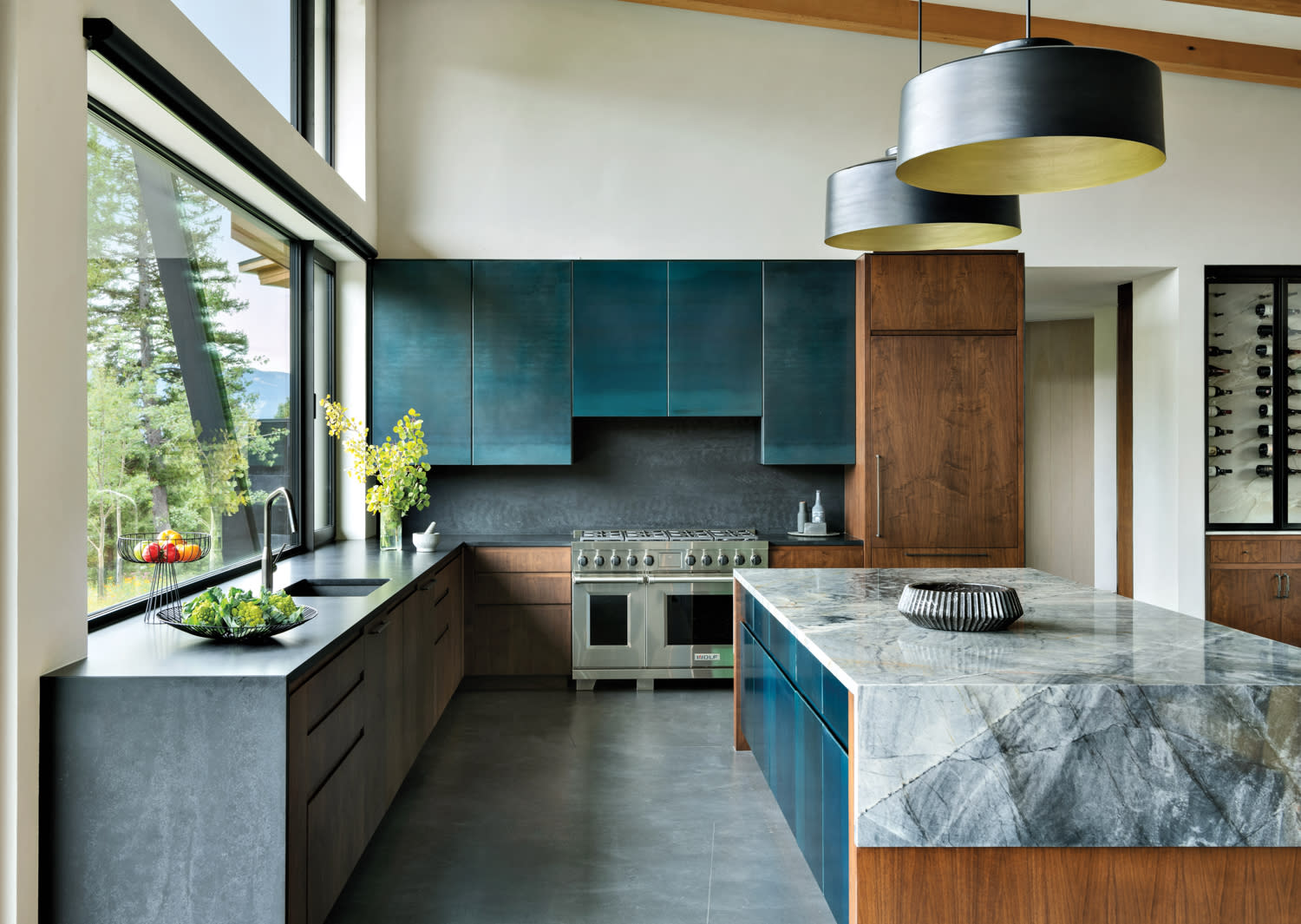 modern mountain kitchen with walnut cabinetry, blue-metal fronted cabinets and a quartzite island